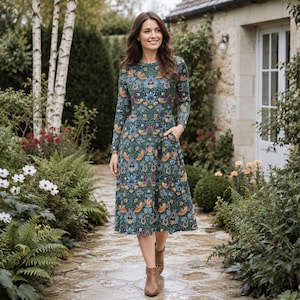May include: A long-sleeved midi dress featuring a dark green background with a dense, colorful botanical print of birds, flowers, and foliage. The dress has a round neckline, a fitted bodice, a flared skirt with side pockets, and hits below the knee.