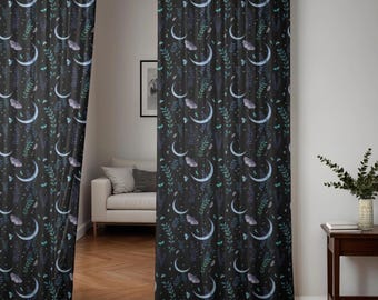 May include: Dark, patterned curtains with a celestial design. The fabric features a repeating pattern of crescent moons, butterflies, and leafy sprigs in shades of blue, purple, and green against a black background. The curtains are hanging in a doorway.