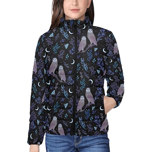 Könnte beinhalten: Eine schwarze Steppjacke mit Reißverschluss und einem sich wiederholenden Muster aus Eulen, Mondsicheln und Blättern. Die Eulen sind hellgrau mit dunklen Augen und sitzen auf Ästen.