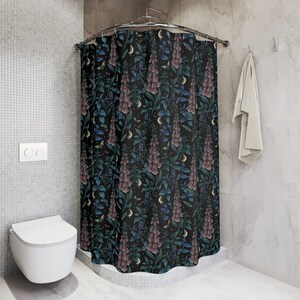 May include: A black shower curtain with a floral pattern featuring pink and blue flowers, green leaves, and gold crescent moons.