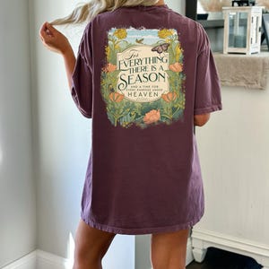May include: A purple t-shirt with a floral design and the text "For everything there is a season and a time for every purpose under heaven".