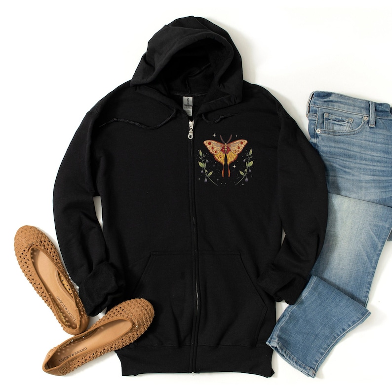 May include: Black zip-up hoodie with a colorful butterfly graphic on the front. The butterfly has yellow, orange, and red wings with black outlines. The hoodie has a hood and a zipper closure.