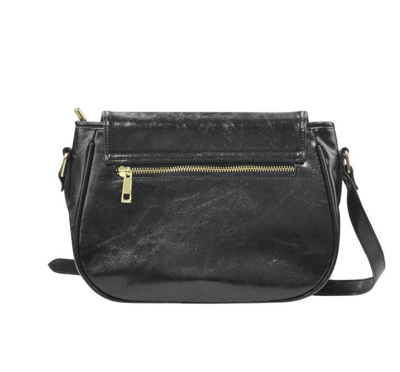 May include: A black leather satchel handbag with a gold zipper and a flap closure. The bag has a shoulder strap.