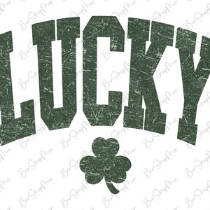 以下が含まれることがあります： 大胆なアーチ型のフォントで「LUCKY」という文字が描かれた、使い古された緑色のグラフィック。その下に緑色のシャムロックがあります。このデザインは、聖パトリックの祝日や幸運を祝うのに最適な、ヴィンテージ感のある外観をしています。
