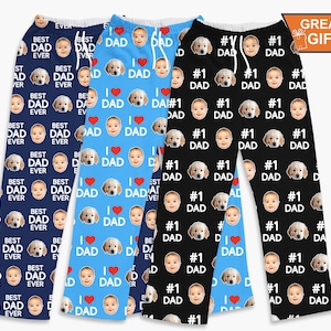 May include: Three pairs of personalized pajama pants. One pair is navy blue with "Best Dad Ever" text and baby and dog faces. Another is light blue with "I Love Dad" text and baby and dog faces. The third is black with "#1 Dad" text and baby and dog faces.