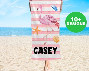 May include: Pink flamingo beach towel with pink and white stripes, a starfish, seashells, and the name "CASEY" printed in black.