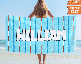 May include: A blue and orange beach towel with a swimming pool lane pattern and the name "William" printed in white.