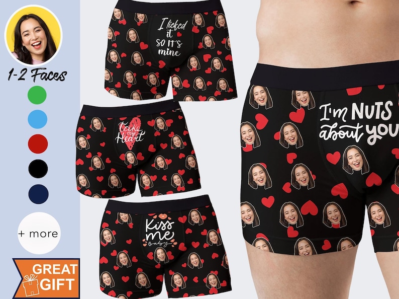 Op de afbeelding: Zwarte boxershorts met een herhaald patroon van vrouwen gezichten en rode harten. Sommige shorts hebben de tekst "I licked it so it's mine", "Take my heart", "Kiss me baby" en "I'm nuts about you".