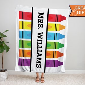 K&ouml;nnte beinhalten: Wei&szlig;e Fleece-Decke mit einem bunten Kreidendesign und dem Text "MRS. WILLIAMS" in Schwarz.
