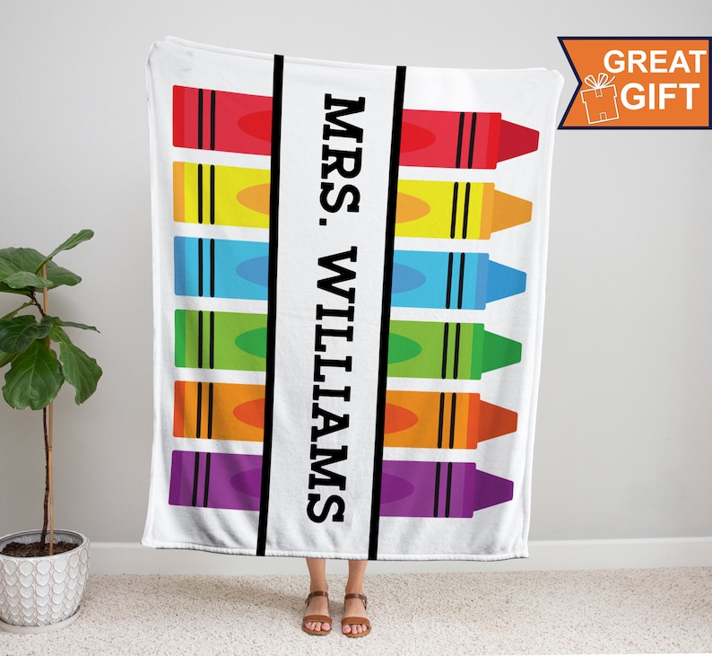 K&ouml;nnte beinhalten: Wei&szlig;e Fleece-Decke mit einem bunten Kreidendesign und dem Text "MRS. WILLIAMS" in Schwarz.