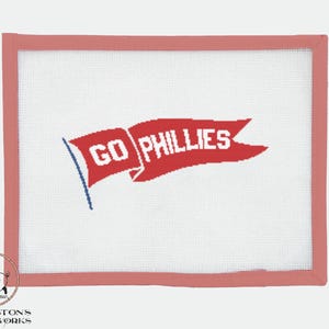 May include: A white canvas with a red banner that says "GO PHILLIES" in white letters. The canvas is framed with a light pink border.