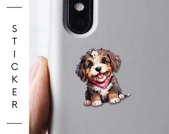 May include: A laminated vinyl sticker featuring a smiling puppy with brown, white, and black fur, wearing a pink bandana. The sticker is affixed to a gray phone case. The brand "BarkRebels" is visible.