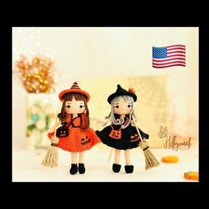 May include: Two crocheted Halloween witch dolls with black and orange dresses, black hats, and brooms. The dolls are standing on a table with a white background.
