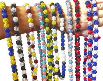 May include: A selection of beaded bracelets in a variety of colours, including yellow, blue, black, silver, red, and pink. Each bracelet is made up of multiple rows of sparkling beads. The bracelets are shown against a white backdrop.