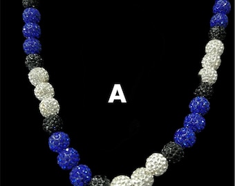 May include: A necklace featuring spherical beads in silver, black, and blue. The beads have a textured, glittery finish. The letter "A" is visible in white in the upper right corner of the image.