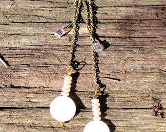 May include: A pair of gold chain earrings with white pearl beads and white round pendants.