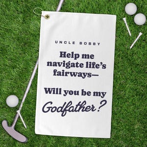May include: White golf towel with the text "Uncle Bobby Help me navigate life's fairways - Will you be my Godfather?" printed in black.