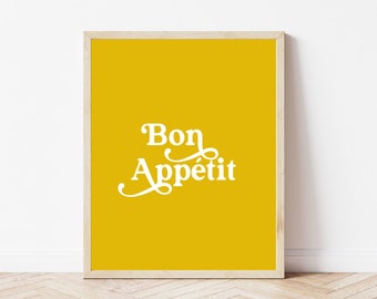 May include: A framed print with a yellow background and white text that says "Bon Appétit".