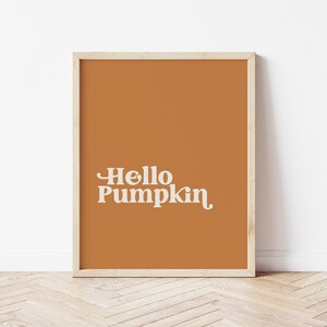 Könnte beinhalten: Ein gerahmter Druck mit braunem Hintergrund und weißem Text, der "Hello Pumpkin" lautet.