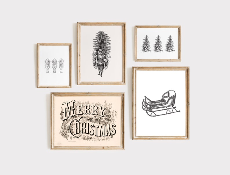 May include: A collection of framed Christmas-themed art prints. The prints feature black and white illustrations of Santa Claus, a sleigh, Christmas trees, and the words "Merry Christmas" in an ornate font. The frames are a light wood color.