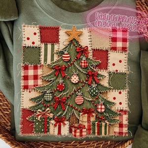 Könnte beinhalten: Ein olivgrünes Sweatshirt mit Rundhalsausschnitt und einem zentralen quadratischen Aufdruck eines Weihnachtsbaums. Der Baum ist mit rot-weißen Ornamenten, Schleifen und einem goldenen Stern verziert, umgeben von einem Patchwork-Muster.