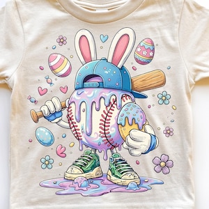 May include: A cream-colored t-shirt featuring a whimsical baseball character with an Easter theme. The baseball has a melting ice cream design, wearing a blue cap with bunny ears, and holding a baseball bat and an ice cream cone. The shirt has the text "DAVINCIPRINTSHOP" and "ORIGINAL DESIGNER".