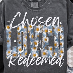 May include: Dark gray sweatshirt with the words "Chosen Loved Redeemed" in white script. The word "Loved" is filled with a daisy floral pattern against a light blue background. The top left corner has the text "DAVINCIPRINTSHOP".