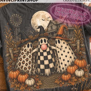 May include: A charcoal gray t-shirt featuring a graphic of three ghosts wearing witch hats in a field with pumpkins, a windmill, and a house under a full moon. The ghosts have floral, checkered, and polka dot patterns. Text reads DAVINCIPRINTSHOP.