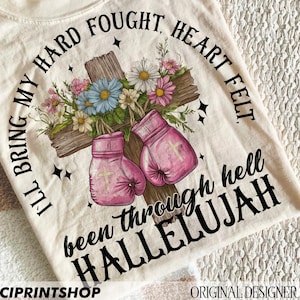 Może przedstawiać: Beżowa koszulka z kwiatowym wzorem i rękawicami bokserskimi. Na koszulce nadrukowany jest tekst "I'll bring my hard fought, heart felt been through hell HALLELUJAH".