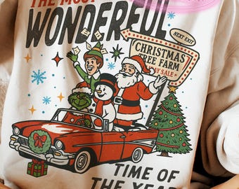 May include: Cream-colored sweatshirt with a festive Christmas graphic. The design features Santa Claus, an elf, a snowman, and the Grinch in a red convertible. Text includes "THE MOST WONDERFUL TIME OF THE YEAR" and "CHRISTMAS TREE FARM".