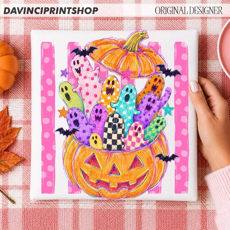 May include: A square canvas print featuring a large orange jack-o'-lantern filled with colorful, patterned ghosts and bats. The background consists of vertical pink stripes with white polka dots. The text DAVINCIPRINTSHOP and ORIGINAL DESIGNER appears.