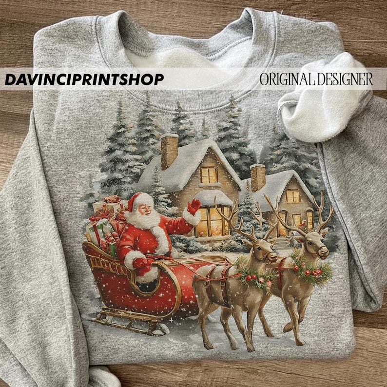 May include: A grey sweatshirt with a festive Christmas design. The image shows Santa Claus in a red sleigh, pulled by reindeer, with snow-covered houses and trees in the background. The text "DAVINCIPRINTSHOP" and "ORIGINAL DESIGNER" are printed on the sweatshirt.