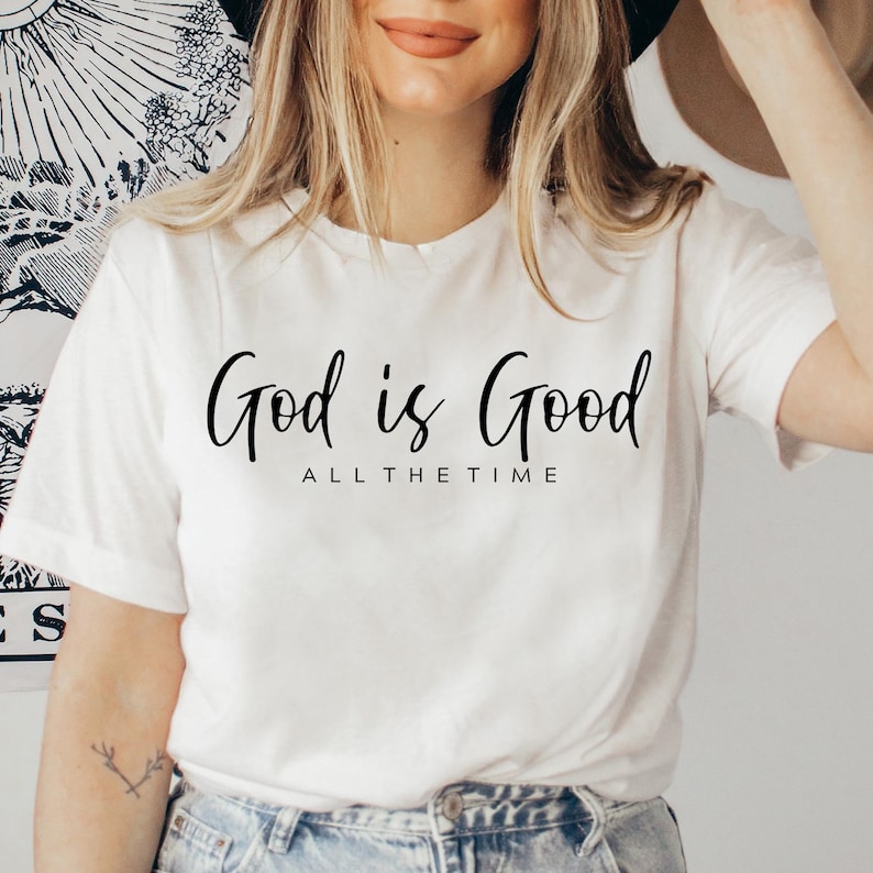 May include: White t-shirt with the text "God is Good All The Time" in black script.