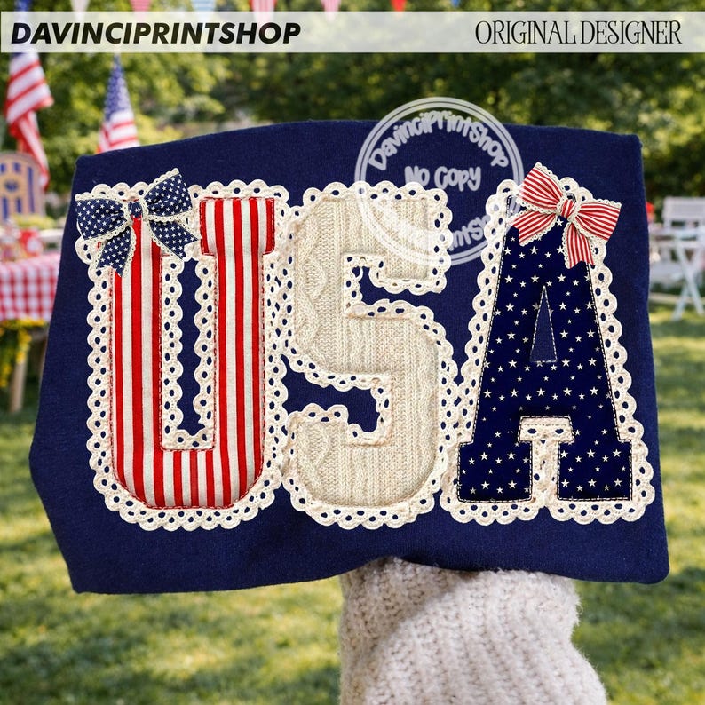 May include: A navy blue decorative item with the letters "USA" in red and white stripes, cable knit, and navy blue with white stars. Each letter is outlined with a white lace trim and topped with a bow. The text "DAVINCIPRINTSHOP" and "ORIGINAL DESIGNER" are visible.