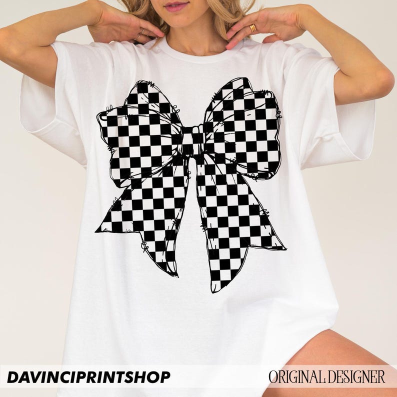 May include: White t-shirt featuring a large black and white checkered bow graphic. The bow design has a hand-drawn aesthetic. The text "DAVINCIPRINTSHOP" is at the bottom left, and "ORIGINAL DESIGNER" is at the bottom right.