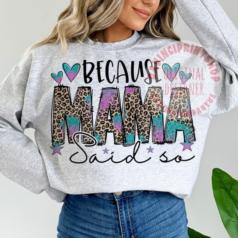 May include: A gray sweatshirt with the text "Because Mama Said So" in pink, blue, and black letters with a leopard print design. The text is surrounded by pink and blue hearts and stars.