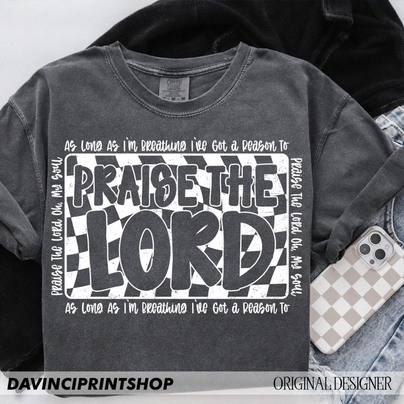 May include: A gray t-shirt with a white checkered design and the text "Praise The Lord Oh, My Soul" and "As Long As I'm Breathing I've Got a Reason To" on the front.