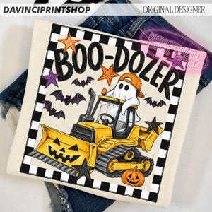 May include: A graphic print featuring a yellow bulldozer with a jack-o'-lantern blade, a ghost wearing an orange cap, and the text BOO-DOZER. The design includes purple and orange stars, small bats, and a black and white checkered border.