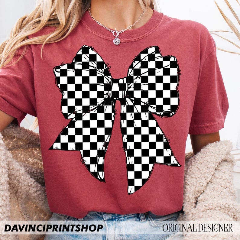 May include: A maroon t-shirt featuring a large bow design with a black and white checkered pattern. The text "DAVINCIPRINTSHOP" is at the bottom left, and "ORIGINAL DESIGNER" is at the bottom right.