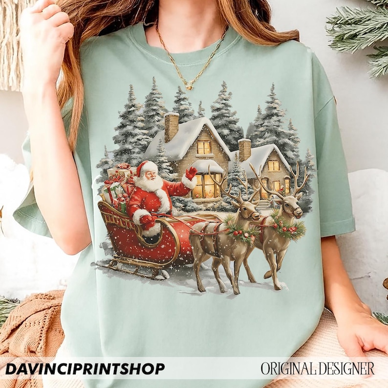 May include: A pale green t-shirt with a festive Christmas design. It shows Santa Claus in a red sleigh, pulled by reindeer, against a backdrop of snow-covered houses and fir trees. The text "DAVINCIPRINTSHOP" and "ORIGINAL DESIGNER" are at the bottom.