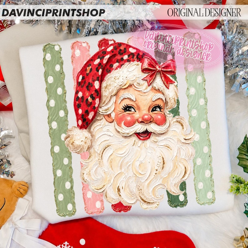 May include: A white sweatshirt featuring a graphic of Santa Claus with a red leopard print hat and a red bow. The design includes vertical stripes in sage green and light pink with white polka dots. The text DAVINCIPRINTSHOP and ORIGINAL DESIGNER appear.