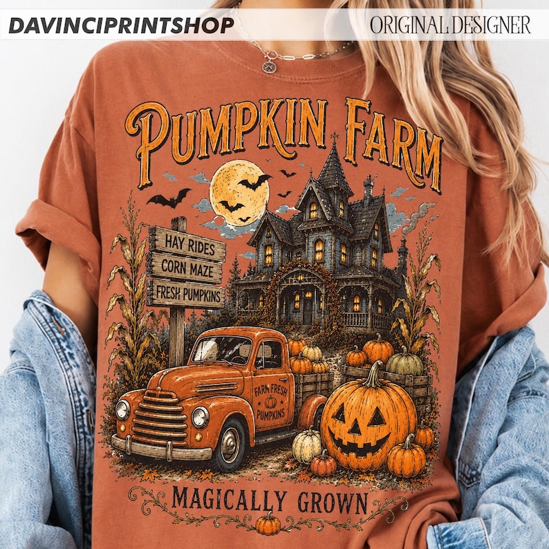 K&ouml;nnte beinhalten: Ein rostfarbenes T-Shirt mit einem Grafikdruck eines Spukhauses, eines alten orangefarbenen Lastwagens und eines gro&szlig;en K&uuml;rbiskopfs. Der Text lautet PUMPKIN FARM und MAGICALLY GROWN, mit einem Schild f&uuml;r HAY RIDES, CORN MAZE und FRESH PUMPKINS.