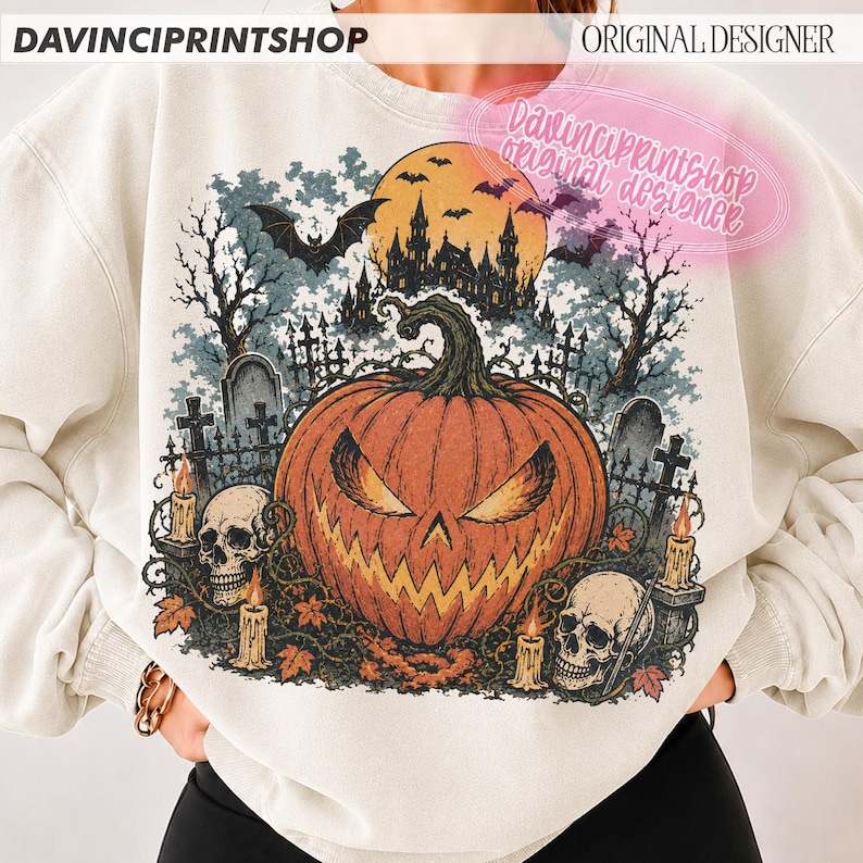 May include: A cream-coloured crewneck sweatshirt featuring a large graphic print of a spooky Halloween scene. The design includes a central orange jack-o'-lantern, two human skulls, a haunted castle silhouette, bats, and lit candles.