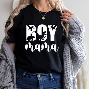 Pode incluir: Camiseta preta com texto branco que diz "Boy mama" com silhuetas de dinossauros.