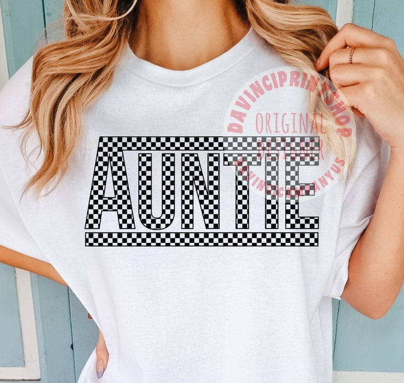 K&ouml;nnte beinhalten: Wei&szlig;es T-Shirt mit einem schwarz-wei&szlig;en Karomuster, auf dem in fetten Buchstaben "AUNTIE" steht.