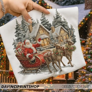 May include: White Christmas cushion cover with a festive design of Santa Claus in a red sleigh, pulled by reindeer, set against snowy houses and trees. The text "DAVINCIPRINTSHOP" is at the bottom.
