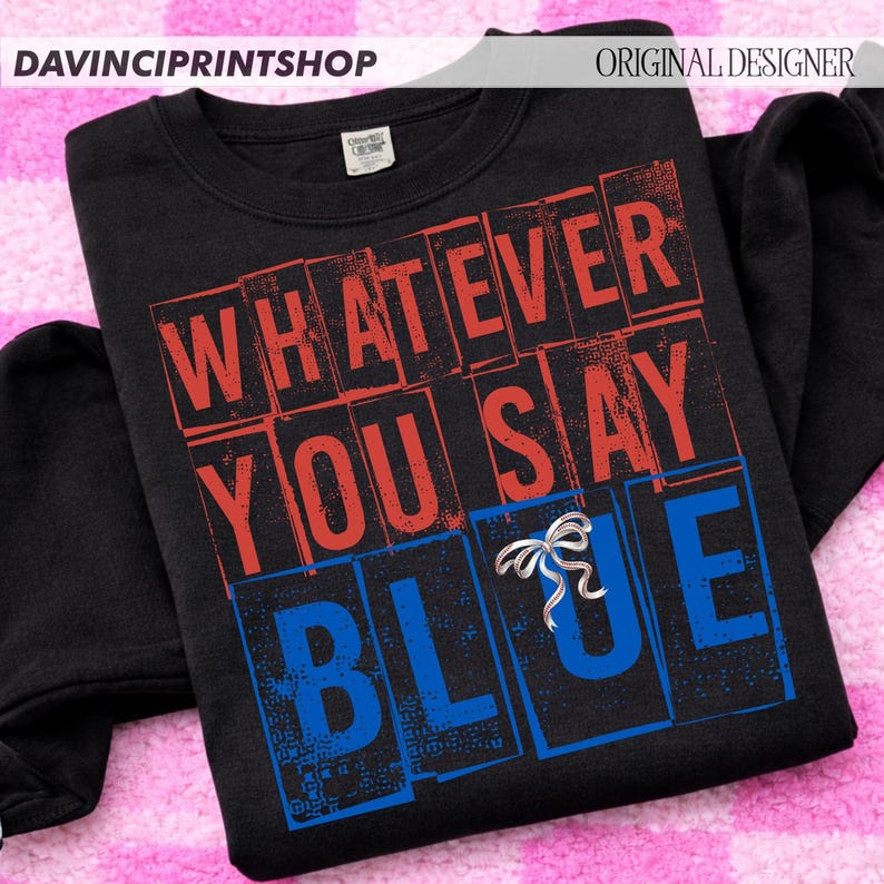 以下が含まれることがあります： 赤と青のブロック文字で「WHATEVER YOU SAY BLUE」と書かれた黒いスウェットシャツ。シルバーのリボンピンが「BLUE」の文字に付いています。スウェットシャツはクルーネックと長袖です。