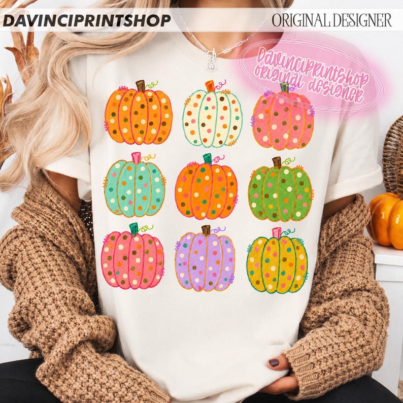 Puede incluir: Una camiseta color crema con una cuadr&iacute;cula de nueve calabazas coloridas, cada una decorada con lunares en varios tonos incluyendo naranja, verde azulado, rosa, verde y morado. El texto DAVINCIPRINTSHOP y ORIGINAL DESIGNER aparece arriba.