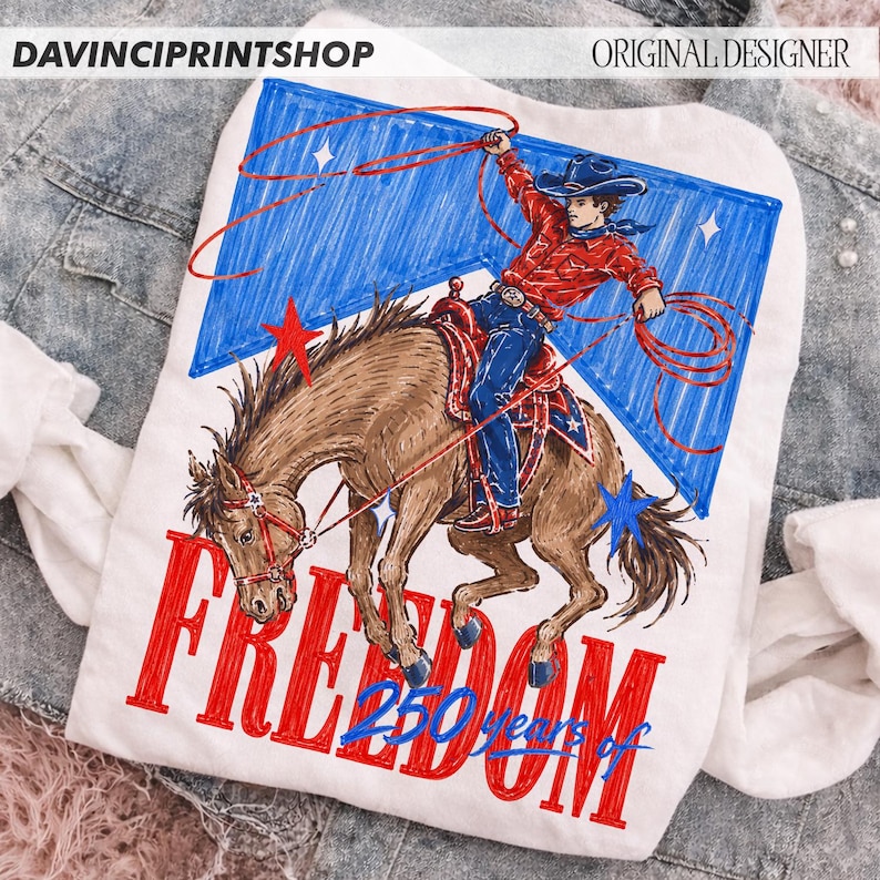 May include: White t-shirt featuring a cowboy riding a horse, roping a lasso, with a blue and red star-spangled background. The word "FREEDOM" is printed in red, with "250 years of" below. The top left corner reads "DAVINCIPRINTSHOP" and the top right corner reads "ORIGINAL DESIGNER".