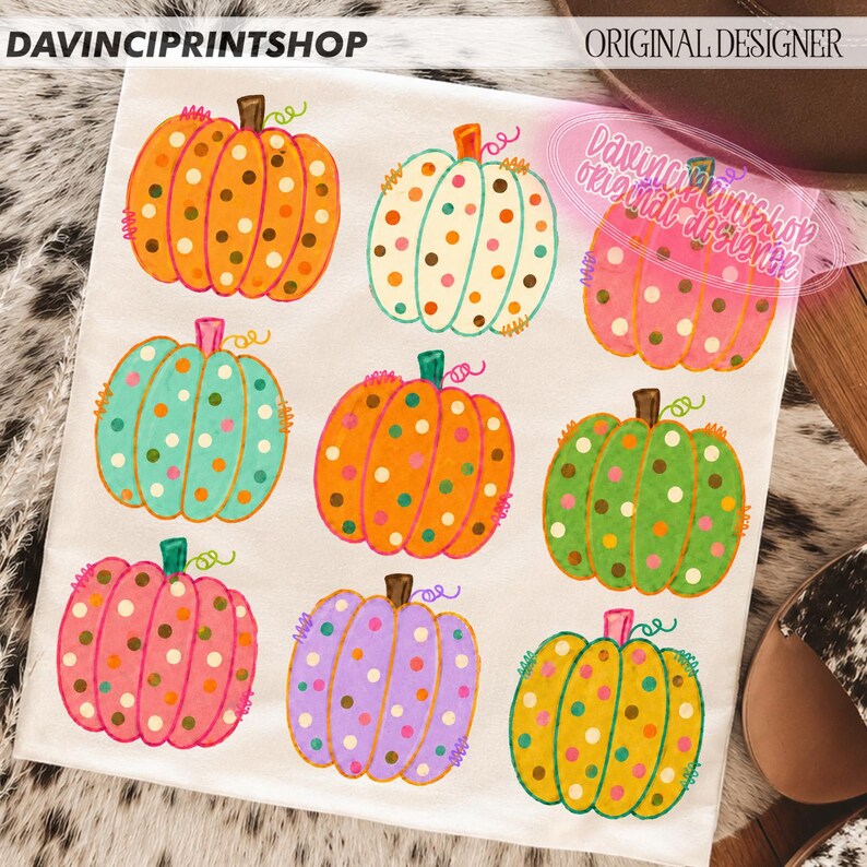 Puede incluir: Una superficie de tela blanca con un patr&oacute;n repetitivo de nueve calabazas en varios colores, incluyendo naranja, blanco, turquesa, rosa, verde, morado y amarillo. Cada calabaza est&aacute; decorada con lunares de colores y tiene un tallo marr&oacute;n.